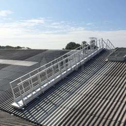Inclined walkway on a factory roof Inclined walkway with guardrails used on a factory roof.
